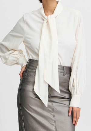 Weiße Seidenbluse mit Krawattenhalsdetail und Puffärmeln, kombiniert mit einem silbernen Satinhosenrock mit einem Frontreißverschluss und Taschen.
