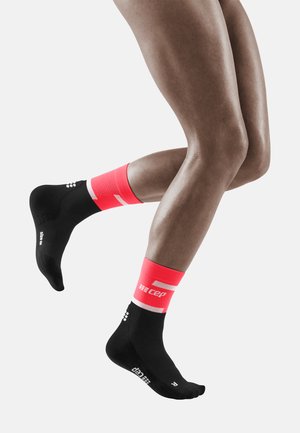 Schwarze Sportsocken mit einem leuchtend pinken und weißen gerippten Bündchen. Enthält Branding an der Seite und strukturierte Akzente an der Sohle.