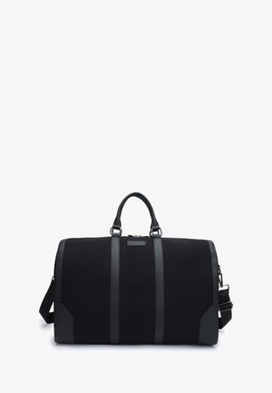 Bolsa de deporte negra con tejido texturizado, detalles en cuero negro, dobles asas en la parte superior y una correa de hombro desmontable. Cuenta con un cierre de cremallera.