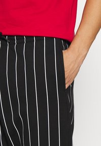 Karl Kani SIGNATURE PINSTRIPE PANTS UNISEX - Treniņtērpa apakšdaļas - black