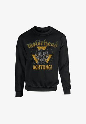 Felpa nera con grafica di un teschio con corna e testo "Motörhead", accentuata da elementi triangolari gialli e scritta invecchiata.