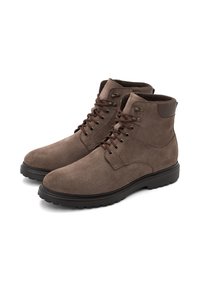 Pruunist seemisnahast pahklu kõrged saapad ümarate ninade, pruunide paelte, metalliste silmade ja musta kummist tallaga, millel on sile tekstuur ja tugevdatud kand.