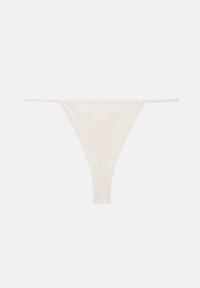 String en tissu côtelé blanc avec fines lanières latérales, posé à plat sur un fond clair.