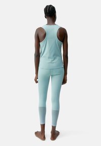 Lichtblauw sporttop met een ronde halslijn en racerback, gecombineerd met bijpassende legging met mesh accenten.