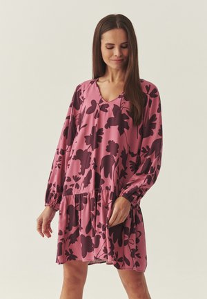 Różowa sukienka z długimi rękawami, dekoltem w kształcie litery V, talią zebrana oraz ciemnym kwiatowym wzorem. Wykonana z gładkiej tkaniny o luźnym kroju.