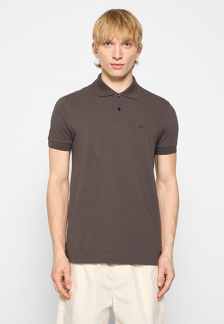 Chemise polo marron en coton lisse. Comprend un col, des manches courtes, deux boutons et un petit logo sur la poitrine.