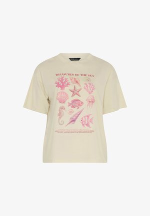 Beige T-paita, jossa vaaleanpunaisia, meriaiheisia kuvituksia, kuten koralleja, meritähtiä, simpukoita, kaloja, meduusoja ja merihevonen, nimeltään "MEREN AARTEET."