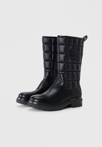 Black high-heeled boots featuring quilted synthetic upper, leather toe, textured accent at heel, and logo detail on the shaft.