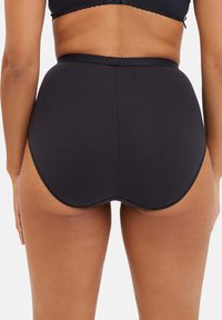 Culotte taille haute noire en tissu lisse et extensible. Dotée d'une taille festonnée et d'un design ajusté pour le confort.