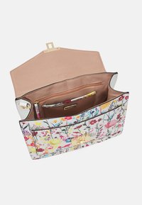 Sac à main à motif floral avec une forme structurée, fabriqué en matériau synthétique. L'intérieur comprend une doublure beige, une poche zippée et un fermoir décoratif.