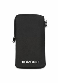 Svart zippered väska i texturerad tyg, med en vit "KOMONO"-logotyp längst ner och en liten tygetikett på sidan.