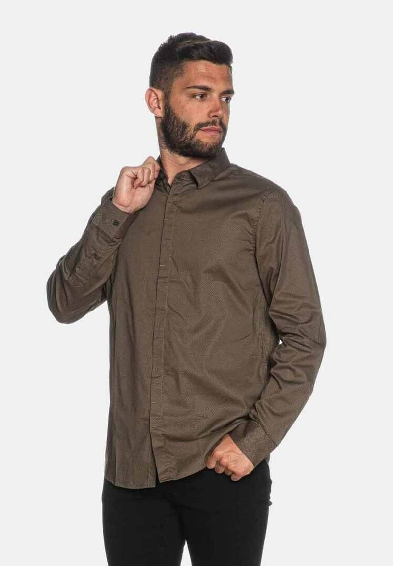 Camicia marrone a maniche lunghe con bottoni, caratterizzata da un motivo sottile, con colletto aperto e polsini abbottonati, realizzata in un tessuto morbido.