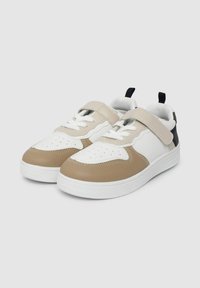 Sneaker con una combinazione di colori bianco, beige e blu navy. Presentano una tomaia in pelle liscia, una punta foro perforato e una fascia regolabile. Suola in gomma piatta.