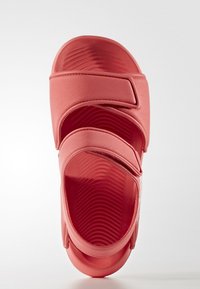 Sandalias de goma coralinas con forma redondeada, que presentan dos correas ajustables y una plantilla texturizada para un mejor agarre. Superficie lisa y diseño flexible.