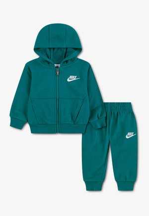 Teal grøn Nike træningsdragt til små børn med lynlåshætte og elastiske bukser, begge med hvide Nike-logoer.