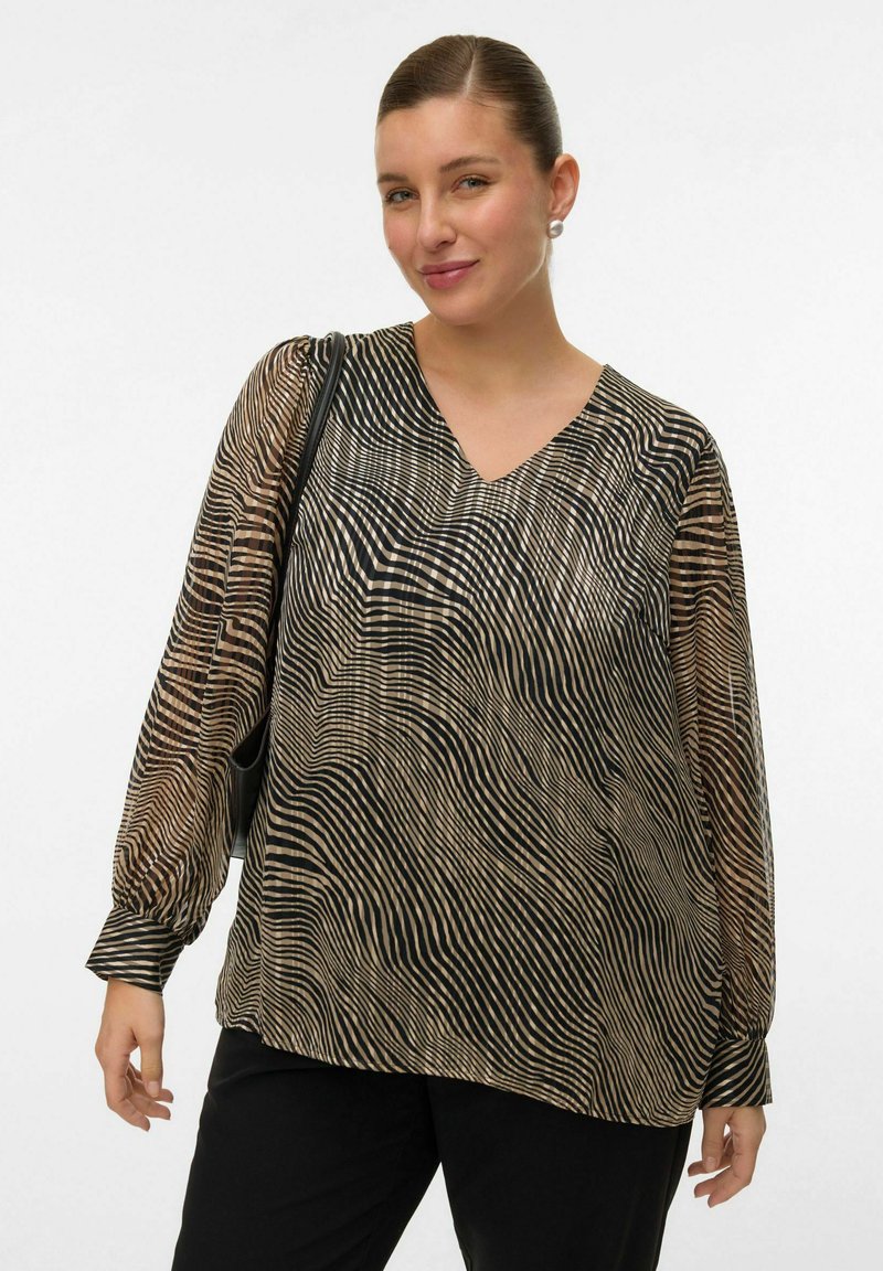 Blouse à manches longues en tissu transparent avec un motif rayé noir et beige ondulé, dotée d'un col en V et d'une coupe décontractée. Pantalons noirs à jambe large.