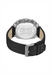Srebrna ura iz nerjavečega jekla s teksturiranim črnim usnjenim paščkom. Zadnja stran ima sončni vzorec z vgravirano besedo "POLICE".