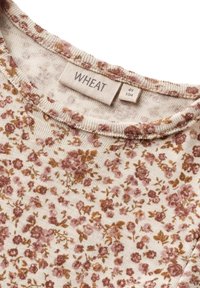Kukkaaiheinen t-paita kerma-värissä, jossa on vaaleanpunaisia ja ruskeita kukkia. Pyöreä pääntie, lyhyet hihat ja etiketti, jossa lukee "WHEAT". Pehmeä, kevyt kangas.