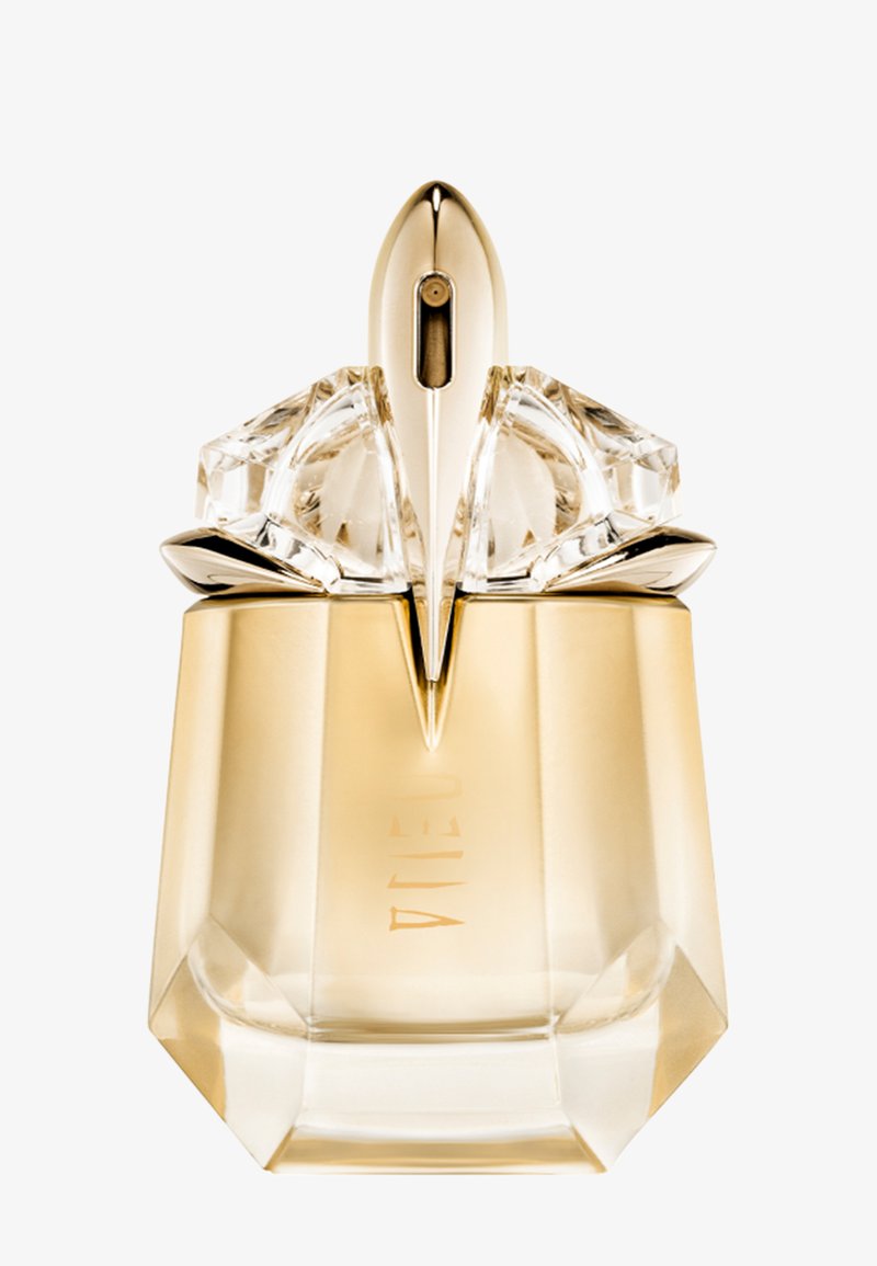 Gennemsigtig gylden parfume flaske med facetslebne kanter og en skulptureret, metallisk gylden spraydyse på toppen.