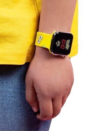 Yellow silicone watch strap featuring cartoon character, square black digital display with red and yellow accents, worn on a child's wrist.