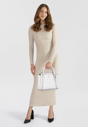 Borsa bianca con un motivo a logo, dettagli in argento e doppio manico; indossata con un lungo vestito beige e tacchi neri. Texture liscia.