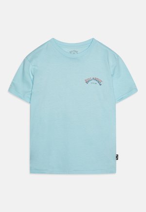 T-shirt bleu clair à manches courtes en coton, avec un petit graphisme logo rouge et bleu sur le devant. Encolure ronde, coupe standard.