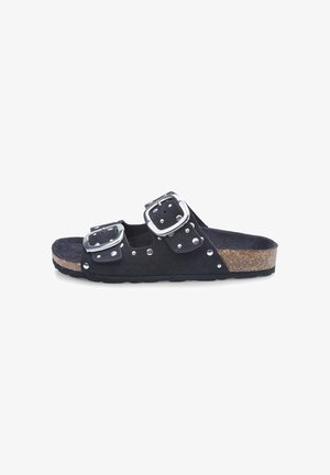 Zwarte suede slide sandaal met twee verstelbare zilveren gespen, studded details en een kurken tussenzool. Platte buitenzool voor comfort.