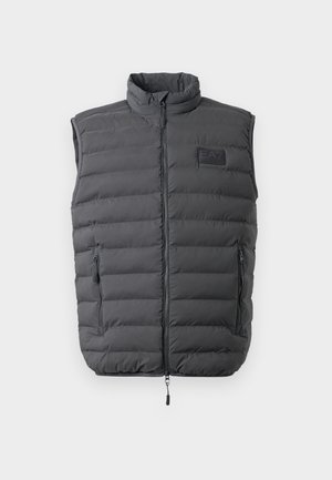 Tummanharmaa pehmustettu liivi, jossa on korkea kaulus, täysi vetoketju ja kaksi sivu-zip-taskua. Rinnassa on logo-patch ja pinta on sileä.