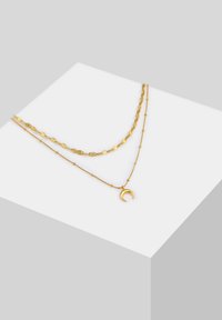 Collana a strati in oro con una catena testurizzata e un pendente a forma di luna crescente liscio. Presenta collegamenti delicati e perline per un dettaglio in più.