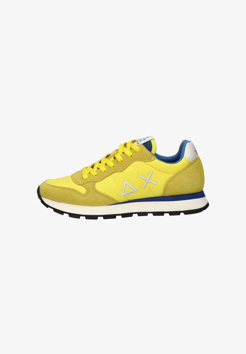 Sneaker giallo in materiali scamosciati e sintetici, con punta rotonda, suola spessa, accenti blu sul colletto e dettagli in grigio del logo.