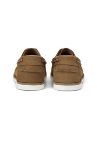 Braune Lederschuhe mit einer strukturierten Oberfläche, weißen Gummisohlen und zwei Schnürsenkeln auf jeder Seite für einen sicheren Sitz. Einfaches, minimalistisches Design.