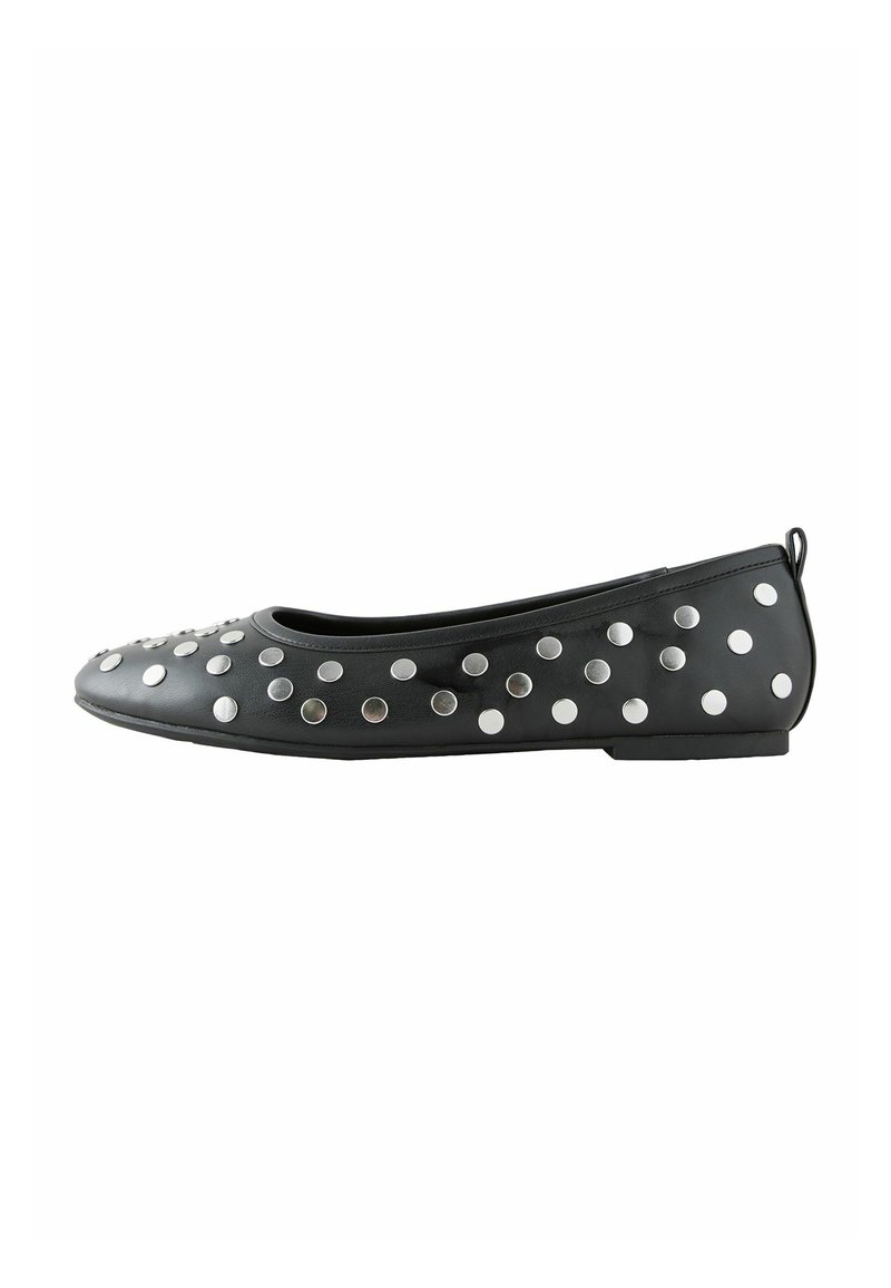 Black flat shoe made of synthetic material, featuring circular silver studs along the upper, with a rounded toe and minimal heel.