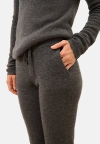 Szary wełniany sweter i spodnie o miękkiej fakturze, z elastycznym paskiem i bocznymi kieszeniami, dopasowany krój.