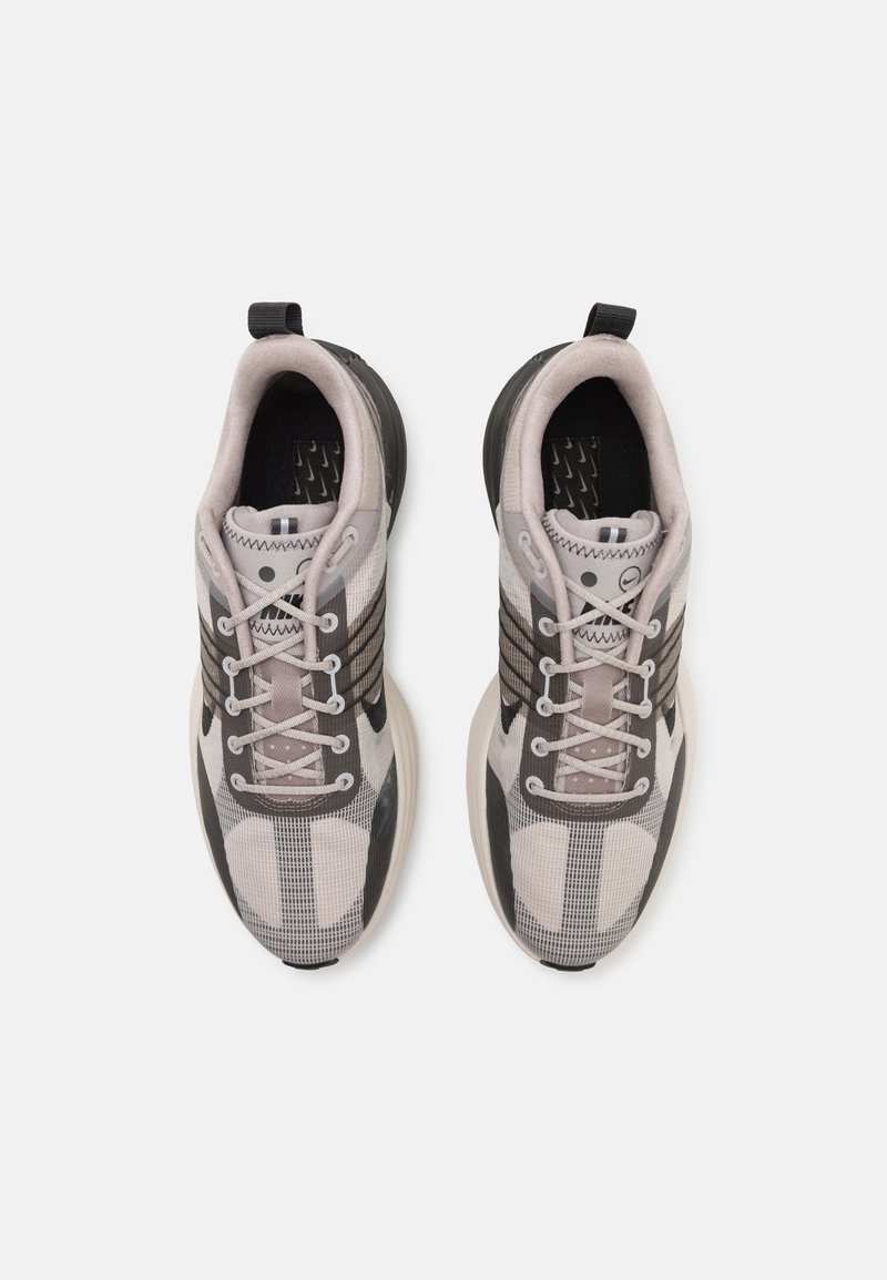 Graue und schwarze Sportschuhe mit einem Obermaterial aus Mesh, strukturiertem Muster, Schnürsenkeln und Gummisohle. Verfügt über eine Ferselasche zum einfachen Anziehen.