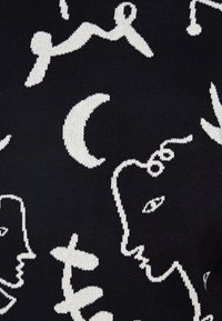 Schwarzer Strickstoff mit weißen abstrakten Designs von Gesichtern, geschwungenen Formen und Monden, mit einer strukturierten Webart im gesamten Stoff.