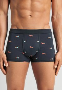 Bóxer de hombre de patrón azul y rojo con fondo oscuro. Fabricado con material elástico, presenta una cinturilla cómoda y un diseño ajustado.