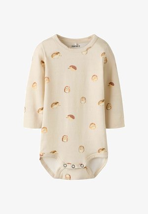 Combinaison à manches longues en coton beige clair avec un imprimé de hérisson répété. Se ferme par des boutons-pression au bas. Texture douce et lisse.