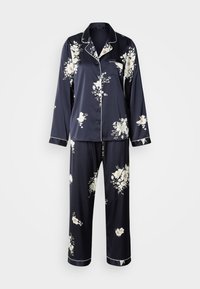 Ensemble de pyjama en satin bleu marine avec des motifs floraux blancs, manches longues et une poche sur la chemise. Le pantalon est ample avec des accents assortis.