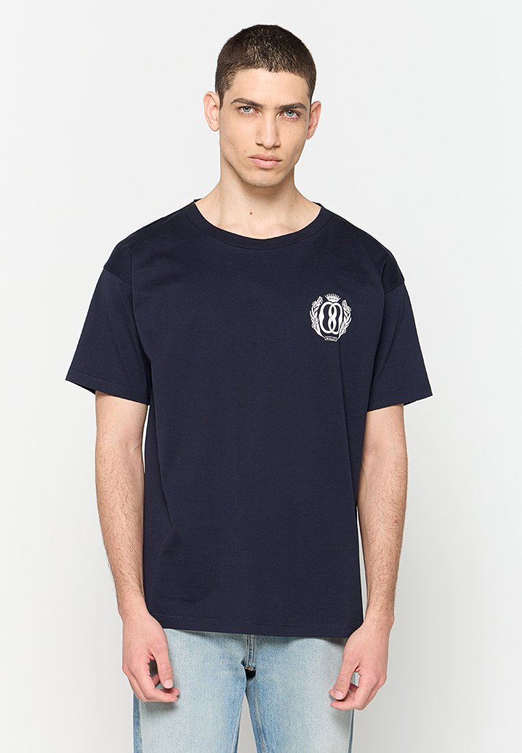 Navyblaue Baumwoll-T-Shirt mit kurzen Ärmeln, rundem Ausschnitt und einem kleinen weißen Logo-Druck auf der linken Brust.