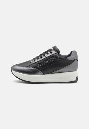 Sort og grå Valentino sneaker med tyk hvid sål, snørebånd foran og Valentino-branding på siden og tungen.