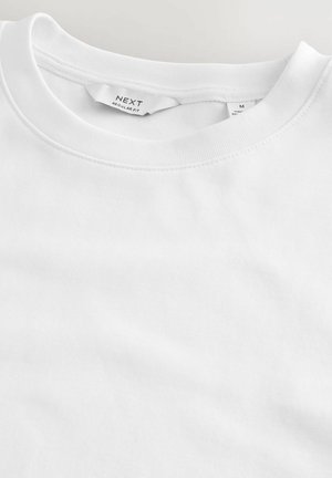Witte katoenen t-shirt met een ronde hals en korte mouwen, met een zachte textuur en het label "NEXT" aan de binnenkant van de hals.