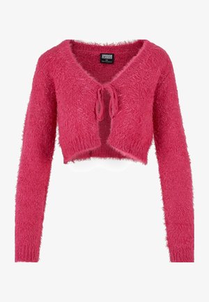 Cardigan court rose en matière moelleuse et texturée. Il possède des manches longues, un décolleté en V profond et une fermeture à nouer à l'avant.