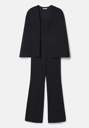 Mustmust, millel on loor, lai jalalõige, ühtlane tekstuur ja seamatu kaelus, sobib ametlikeks üritusteks.