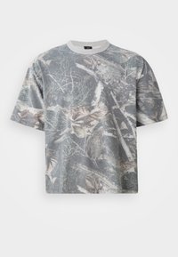 Kortærmet T-shirt i grå med camouflage-mønster, der viser blade og grene. 100% bomuldsstof, rund halsudskæring, afslappet pasform.
