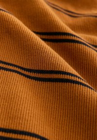 Material ribbed de culoare portocalie cu dungi negre orizontale. Textura pare moale și ușor elastică, punând în evidență modele fine de tricot.