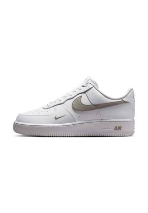 Biele nízke tenisky Nike Air Force 1 s svetlosivými logo swoosh a hrubou textúrovanou podrážkou.