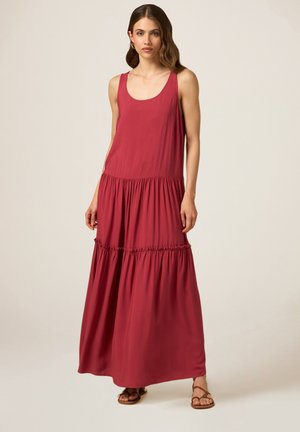 Abito lungo senza maniche di colore rosso realizzato in un tessuto morbido, con vita arricciata e gonna a strati. Design semplice con una silhouette fluida.