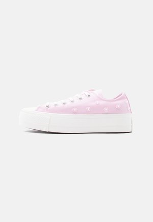 Sneaker basses en toile rose avec motifs de marguerites blanches, semelle en caoutchouc blanche et lacets blancs, vues de profil sur fond blanc.