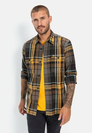 Kariertes Flanellhemd mit schwarzen, braunen, gelben und hellblauen Mustern, zwei Brusttaschen und einem Button-Down-Kragen.