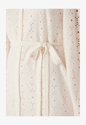 Biała szata z tkaniny z misternym wzorem haftu angielskiego w kwiaty, związywana pasującym paskiem, charakteryzująca się miękkim, teksturowanym wyglądem.